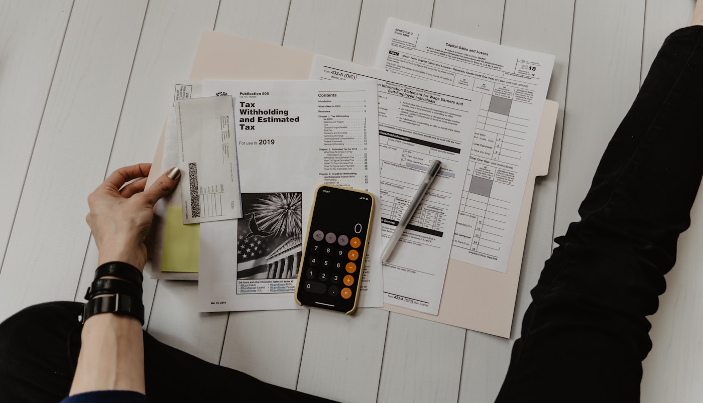 Calculator, pen, and financial documents on a desk.