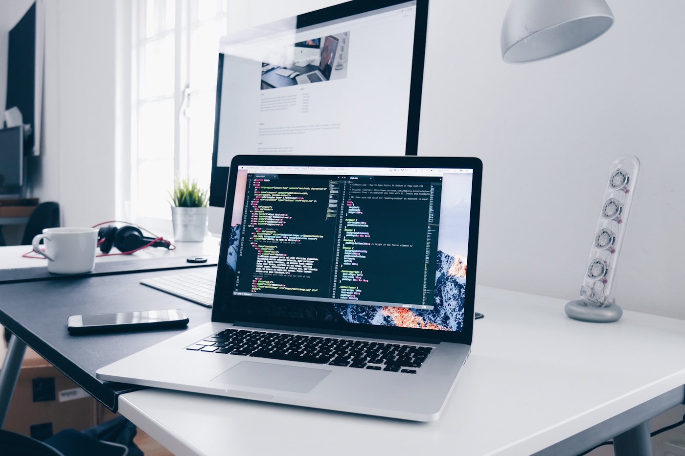 Laptop on a desk with code or design on screen.